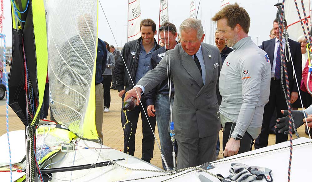 King Charles pictured with members of the British Sailing Team including 49er duo Stevie Morrison and Ben Rhodes whose new boat he christened. 