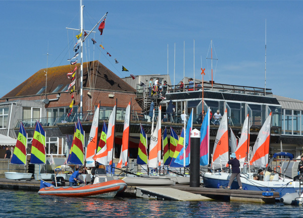 Lots of boats outside of a club house