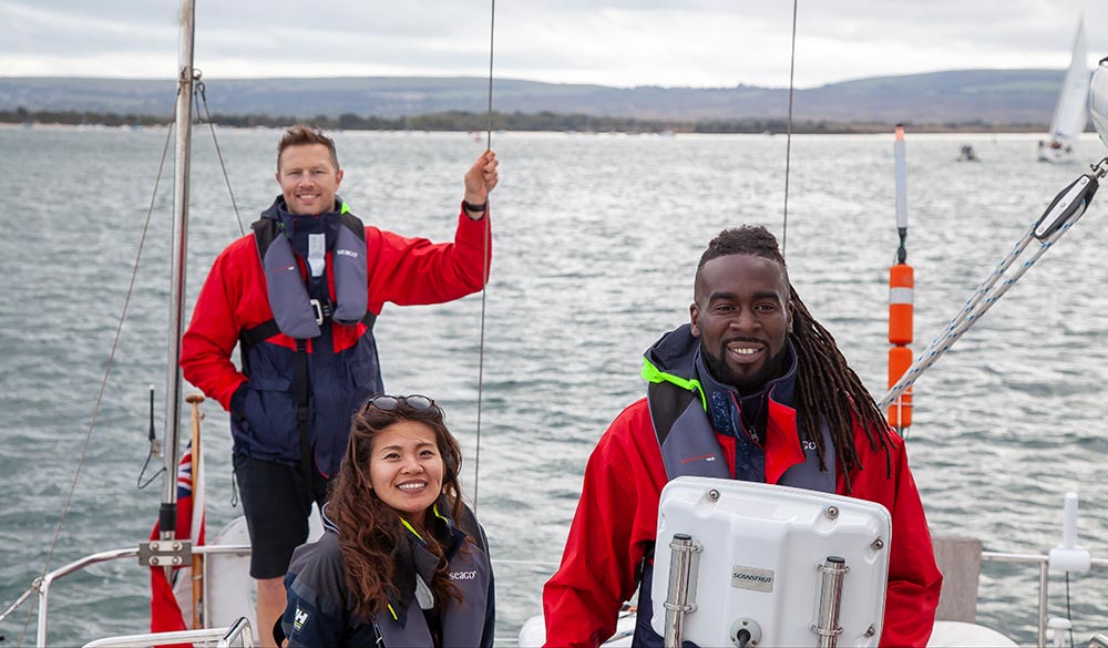 Wide shot of sailors using electronic navigation on boat