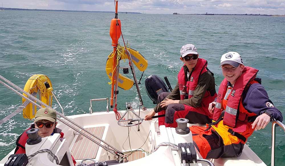 Cameron Gardner on a boat with other young sailors