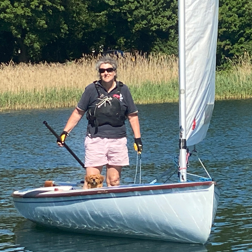 Vanessa sailing with her dog on a dinghy on the river