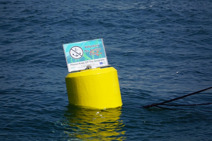 Sign in the water displaying that this is a voluntary no anchor zone 